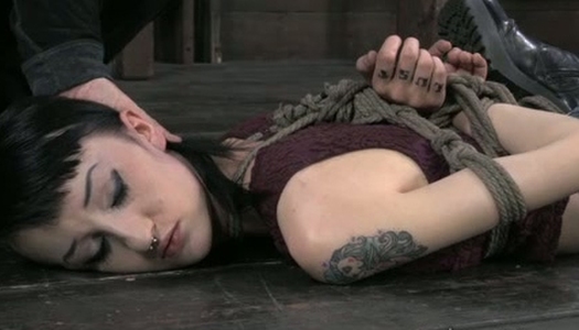 Pornobild Brünettes Küken liegt mit gefesselten Händen auf dem Boden