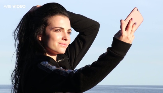 Pornobild Die ziemlich heiße Brünette Sapphira blitzt ihre Titten am felsigen Strand auf